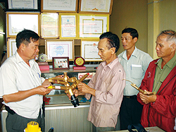 Ông Tám (thứ ba, từ phải sang) đang giới thiệu sản phẩm béc tưới với khách hàng
